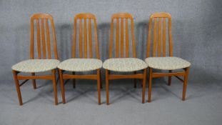 A set of four mid century vintage teak dining chairs on shaped circular section stretchered