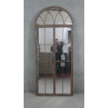 A metal framed arched garden mirror. H.180 W.78cm (Plate damaged as photographed).
