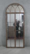 A metal framed arched garden mirror. H.180 W.78cm (Plate damaged as photographed).