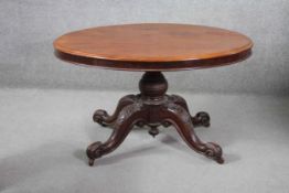 A Victorian mahogany dining table on baluster turned pedestal base on carved quatreform cabriole