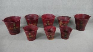A collection of eight hand painted red metal Coca Cola design buckets. H.33 D.33cm (largest)