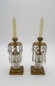 A pair of 19th century gilt brass and cut glass candlesticks each with crystal drops and mounted