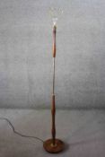 A vintage teak and brass standard lamp on circular base. H.152 Diam. 24cm (base)