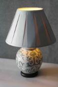 A hand painted crackle glass ceramic table lamp with a stylised foliate and cornucopia design on