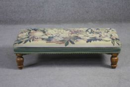 A Victorian style foot stool in tapestry upholstery on beech baluster turned supports. H.24 W.80.