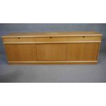 A Danish light teak sideboard fitted with drawers and sliding doors on plinth base by Mogens Kold.