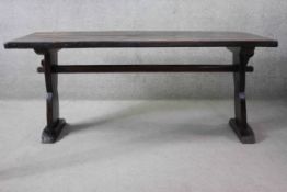 A mid century oak refectory style dining table with planked top on stretchered trestle supports. H.