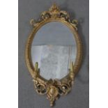 A 19th century girandole the oval plate in gilt gesso foliate decorated frame with twin candle