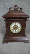 An American Ansonia carved mahogany mantle clock with white enamel dial, brass movement and