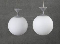 A pair of vintage white frosted glass spherical ceiling lights with chrome fittings. Diam.30cm