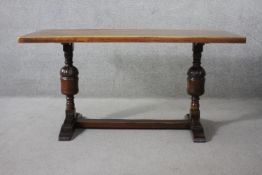 A mid century oak Jacobean style refectory dining table on carved baluster stretchered platform