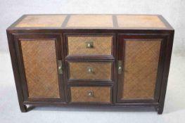 An Eastern hardwood and rattan sideboard on shaped block feet and brass fittings. W.140cm (