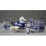 A collection of seven pieces of porcelain. Including a pair of blue willow pattern candlesticks,