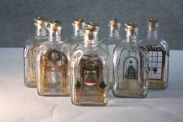 Eight Holmegaard Danish Advent decanters by Michael Bang. Each with a gilded and colourful festive