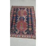 A Shirvan rug with central lozenge medallions on a midnight ground contained by stylised foliate