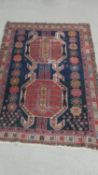 A Shirvan rug with central lozenge medallions on a midnight ground contained by stylised foliate