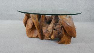John Behm, a contemporary coffee table with plate glass top on carved natural wood base. H.46 Diam.