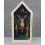 A cased painted and carved wood crucifixion scene with three figures on a painted background. H.70