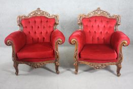 A pair of carved foliate walnut Italian style armchairs in deep buttoned velour upholstery.