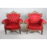 A pair of carved foliate walnut Italian style armchairs in deep buttoned velour upholstery.