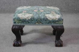 A Georgian style mahogany stool with floral upholstered stuff over seat on carved cabriole ball