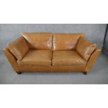 An Art Deco style two seater sofa in light tan leather upholstery. H.84 W.179 D.97cm