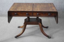 A Regency mahogany drop flap sofa table fitted with a pair of frieze drawers opposing dummy