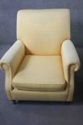 A Victorian style armchair in piped lemon velour upholstery on mahogany turned bun feet resting on