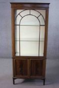 A C.1900 mahogany display cabinet with arched glazed door above panel doors on square tapering