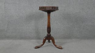 A 19th century mahogany pedestal torchere with pierced hexagonal top on carved baluster turned
