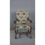 A 19th century Continental walnut armchair in stylised floral tapestry upholstery and lion carved