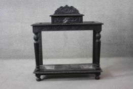 A late 19th century oak umbrella stand with mask carved frieze drawer and twin stick sections with
