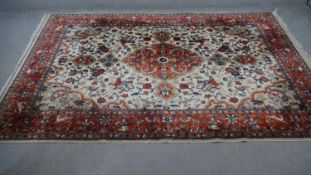 A handmade Persian Sarouk carpet with central floral medallion and hunting motifs with trailing