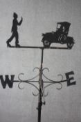 A painted black cast iron weather vane and pole with a farmer and tractor and points of a compass.