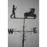 A painted black cast iron weather vane and pole with a farmer and tractor and points of a compass.