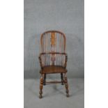 A 19th century elm Windsor armchair with pierced and carved central splat on turned and