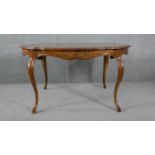 A French Provincial style walnut extending dining table with quarter veneered top and extra leaf