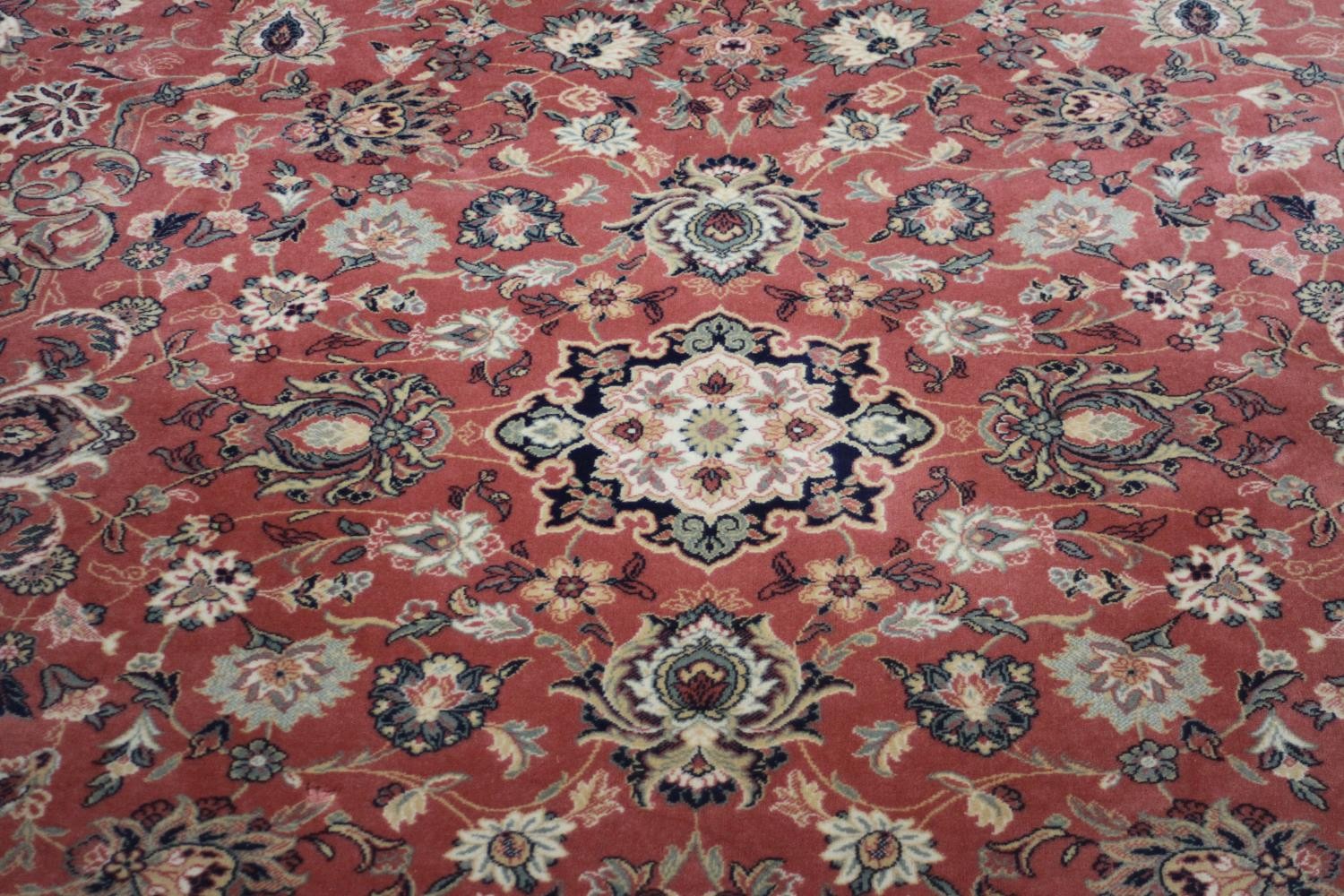 A Keshan motif woollen carpet with central medallion and trailing foliate pattern on a burgundy - Image 2 of 5