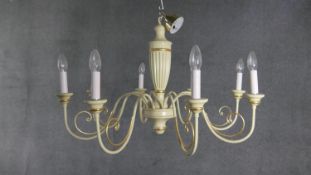 A large cream painted and gilded carved and metal scrolling design eight branch chandelier. H.50 W.
