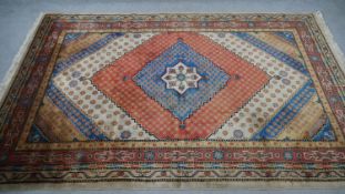 A Samarkand carpet with polychrome central diamond medallions within stylised floral multiple