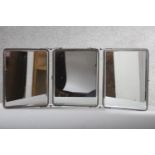 A vintage chrome framed bevelled plate triptych folding mirror with fabric backing. H.31 W.74. cm.
