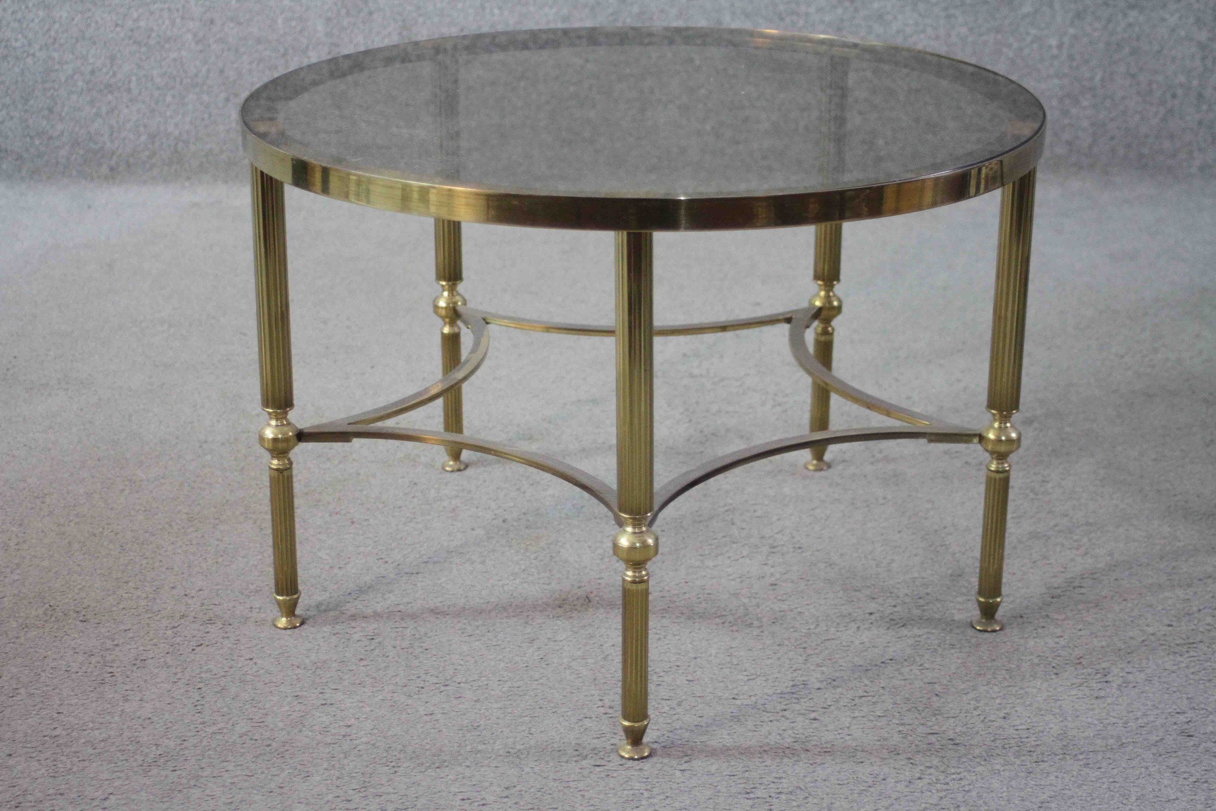 A mid century vintage smoked glass and brass lamp table on shaped stretchered supports. H.40 Diam.