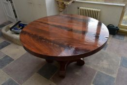 A 19th century Continental flame mahogany circular tilt top table on facetted baluster platform