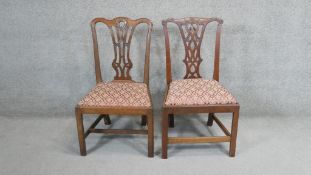 A pair of Georgian mahogany dining chairs with drop in seats on square stretchered supports.