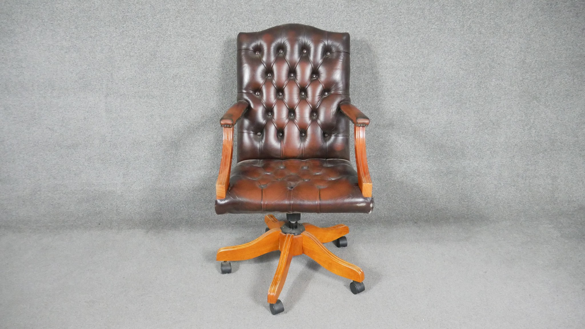 A Georgian style office armchair in deep buttoned leather upholstery with tilt and swivel action.