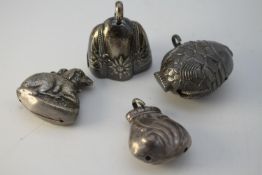 Four white metal and silver bells. One as a fish, one with edelweiss design, one as a money bag with