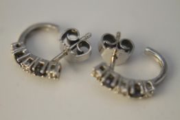 A pair of 14 carat white gold sapphire and diamond creole earrings. Each earring set with two