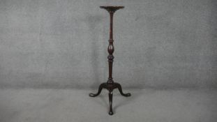 A Georgian style mahogany torchere with dished circular top on baluster turned column on tripod