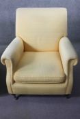 A Victorian style armchair in piped lemon velour upholstery on mahogany turned bun feet resting on