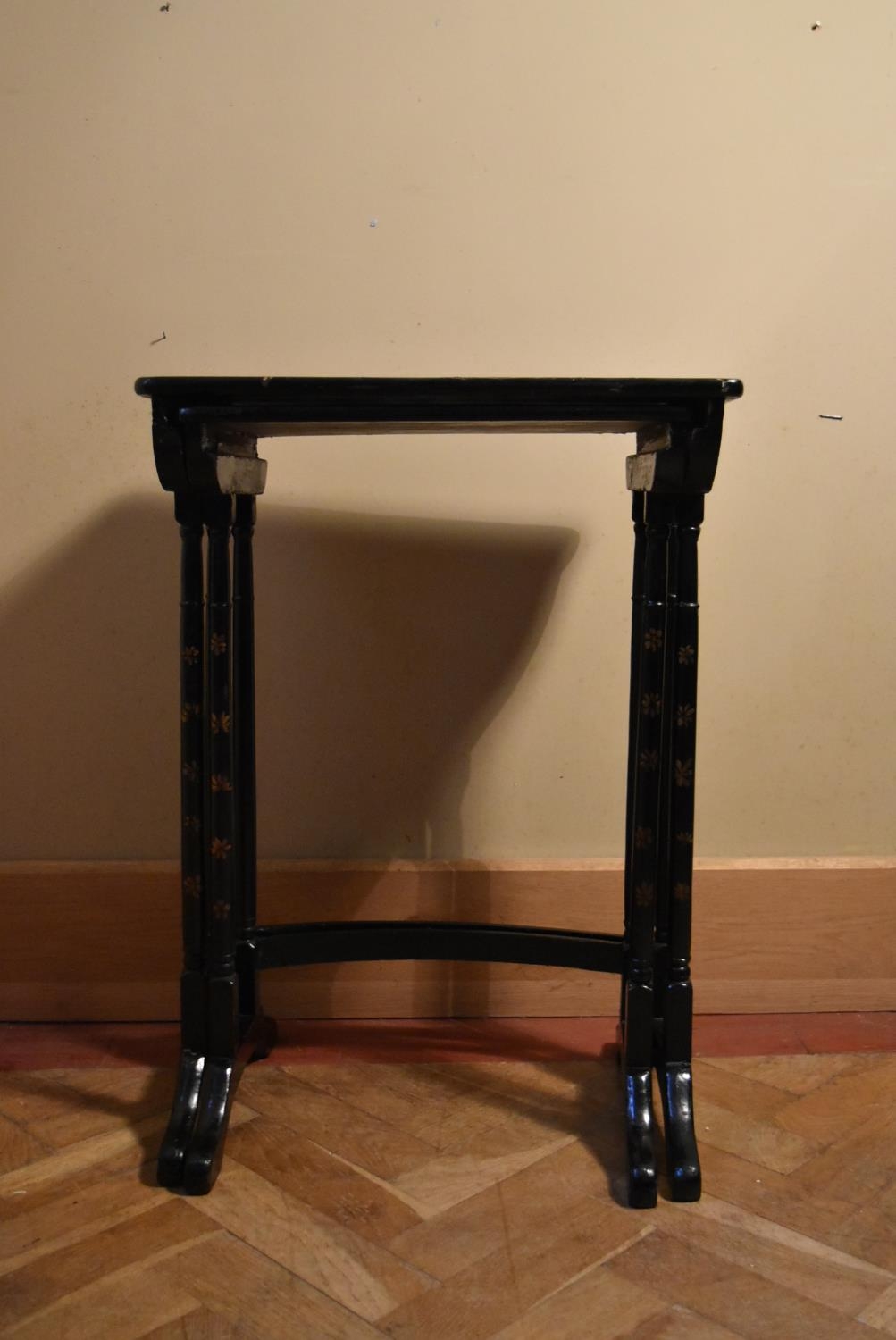 A nest of two hand decorated and black lacquered occasional table in the Chinoiseries style. H.